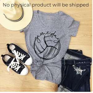 May include: A heather gray V-neck t-shirt with a black graphic of a volleyball and the text "game day" written in cursive. The shirt is tied at the bottom and paired with black canvas sneakers and dark blue distressed denim jeans.