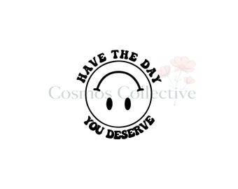 May include: A black and white graphic design featuring a circular outline with two solid black oval eyes and an inverted curved line for a mouth. The text "HAVE THE DAY YOU DESERVE" is arched around the top and bottom of the circular face.