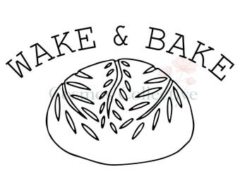 May include: A black and white line art illustration of a round loaf of bread with scored patterns on top. The text WAKE & BAKE is arched in a serif font above the bread. The design features clean black outlines on a plain white background.