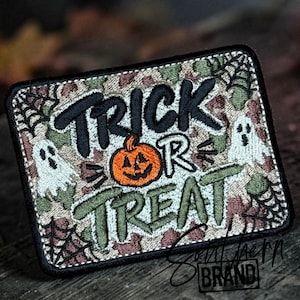 May include: A rectangular embroidered patch featuring a camouflage background with black, white, and green thread. The text reads TRICK OR TREAT in black and green, accompanied by an orange jack-o'-lantern, two white ghosts, and black spiderwebs.