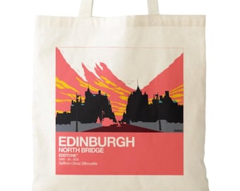 May include: A cream-colored canvas tote bag featuring a graphic print of the Edinburgh North Bridge skyline in black silhouette against a vibrant orange and red sunset sky, with the text EDINBURGH NORTH BRIDGE EDDTONE printed below.