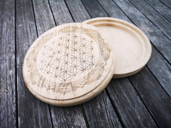 Boîte à bijoux ronde en bois de chêne, avec une gravure d'une fleur de vie entourée d'un mandala. Fabrication artisanale et personnalisable.