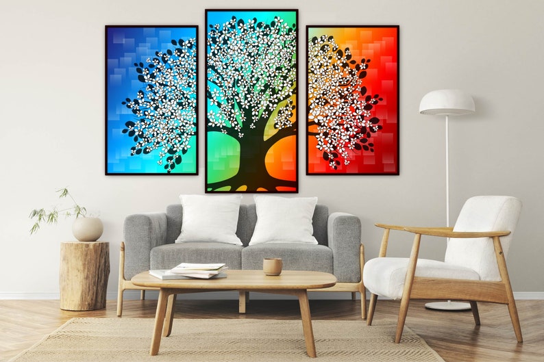 Puede incluir: Un tr&iacute;ptico de impresiones art&iacute;sticas abstractas de &aacute;rboles. Cada lienzo enmarcado presenta una silueta de &aacute;rbol con detalles florales blancos sobre un fondo degradado de azul, verde y rojo. La obra de arte se exhibe sobre un sof&aacute; gris.