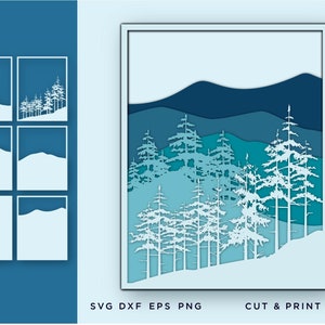 May include: A layered paper art piece depicting a winter forest scene with pine trees and mountains in shades of blue and white. The artwork is framed in a white border. The image also includes smaller design elements and text that reads "SVG DXF EPS PNG" and "CUT & PRINT FILES."