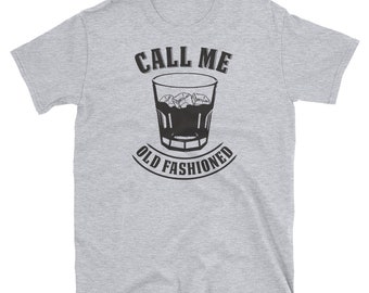 May include: A light gray t-shirt with the text "CALL ME" above a graphic of a glass filled with ice and a dark liquid. Below the glass, the text reads "OLD FASHIONED".