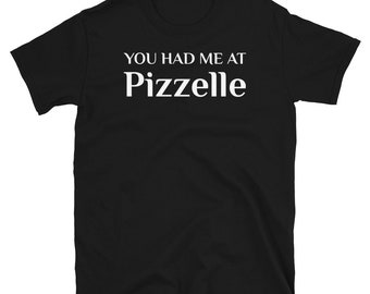 May include: Black short-sleeved t-shirt with white text that reads "You had me at Pizzelle".