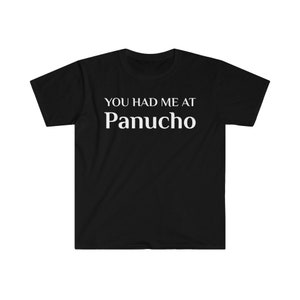 May include: Black t-shirt with the white text "YOU HAD ME AT Panucho". The shirt is made of a soft material and has a classic crew neck design. A casual and comfortable apparel item.