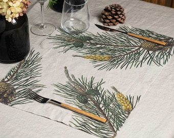 May include: A beige linen placemat with a pine needle and pine cone design. The placemat features a brown wooden fork and knife.