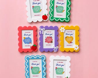 May include: A collection of colorful, scalloped-edge picture frames with the text "Thank you" and personalized messages. Each frame is a different color, including white, green, red, purple, yellow, and blue. Some frames have decorative elements like bows and flowers.