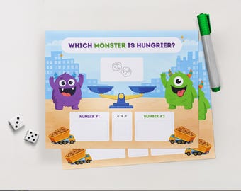 May include: Educational game featuring two cartoon monsters, a balance scale, and dice. The text "WHICH MONSTER IS HUNGRIER?" is displayed. A green and silver marker and two dice are also present.