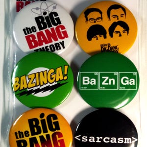 Peut inclure: Ensemble de six badges ronds en forme de bouton représentant des personnages et des thèmes de la série télévisée The Big Bang Theory. Les badges sont jaunes, verts, blancs, noirs et orange avec du texte blanc. Le texte sur les badges comprend "The Big Bang Theory", "Bazinga!" et "<sarcasm>".