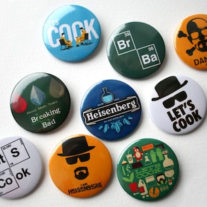Może przedstawiać: Dziewięć okrągłych pinów z różnymi wzorami związanymi z serialem telewizyjnym Breaking Bad. Piny przedstawiają postacie z serialu, kultowe frazy i pierwiastki chemiczne. Piny są kolorowe i mają błyszczące wykończenie.