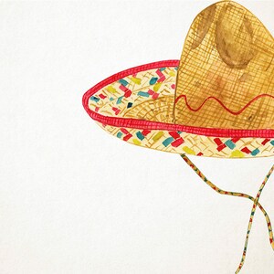 Op de afbeelding: Een bruine en beige geweven sombrero met een rode rand en kleurrijke accenten. De hoed is gemaakt van stro en heeft een brede rand.