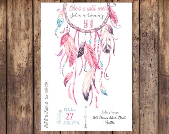 May include: A pink and white dreamcatcher with feathers and beads. The text "She's a wild one! Julia is turning 5!" is written on the invitation. The invitation also includes the date, time, and location of the party.
