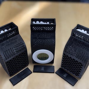 May include: Three black 3D printed containers with white lids and white balls inside. The middle container has a white digital display showing the number 69. The text "Relative Humidity" is printed on the front of each container.