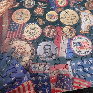 Może przedstawiać: Ukończone puzzle o tematyce patriotycznej. Elementy układanki przedstawiają amerykańskie flagi, postacie historyczne i medaliony w stylu vintage z napisami takimi jak "God Bless America" i "Theodore Roosevelt". Paleta kolor&oacute;w obejmuje czerwień, biel i błękit.