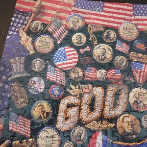 Może przedstawiać: Ukończone puzzle o tematyce amerykańskiej. Elementy układanki przedstawiają amerykańskie flagi, postacie historyczne i słowo "GOLD". Puzzle zawierają obrazy pieczęci stanowych i patriotyczne obrazy.