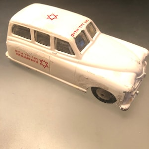 May include: White toy car with red Magen David (Star of David) and the words "Red Magen David" and "Oten Tit 130" on the side.