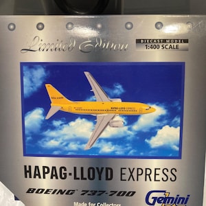 May include: A yellow and white Boeing 737-700 airplane model with "HAPAG-LLOYD EXPRESS" printed on the side. The model is a 1:400 scale diecast model and is part of a limited edition collection by Gemini Jets.