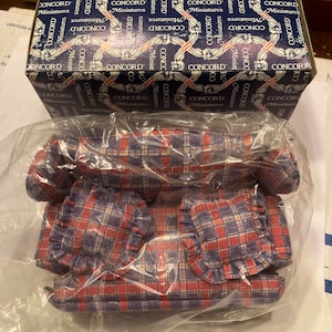 May include: A miniature dollhouse sofa set with red and blue plaid fabric upholstery. The set includes a sofa, two pillows, and a throw blanket. The set is packaged in a clear plastic bag and a blue box with the text "CONCORD Miniatures" printed on it.