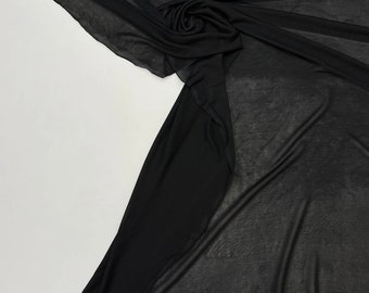 May include: Black sheer fabric with a soft, flowing texture. The fabric is draped and folded, showcasing its delicate and transparent nature.