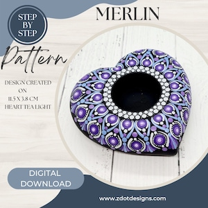 May include: A purple, blue, and white mandala design painted on a black heart-shaped tea light holder. The holder measures 11.5 x 3.8 cm. The design is called "Merlin".