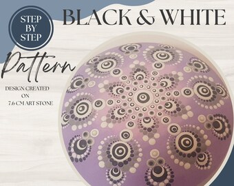 May include: A purple stone with a black and white dot mandala design. The design is created on a 7.6 cm art stone. The image includes the text "STEP BY STEP Pattern" and "DESIGN CREATED ON 7.6 CM ART STONE".