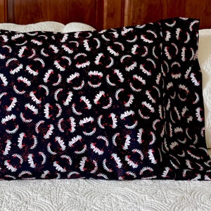May include: A rectangular pillowcase featuring a repeating pattern of white vampire fangs with red gums on a black background. The fabric has a dense, all-over print of sharp teeth arranged in a scattered, non-directional layout across the surface.