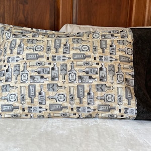 May include: A rectangular pillowcase featuring a repeating pattern of vintage-style glass bottles on a beige background. The bottles are illustrated in shades of gray and black, with some labels clearly displaying the text Rat Poison and skull icons.