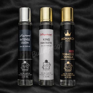 May include: Three cylindrical glass perfume bottles, each containing 20 ml of eau de parfum. The left bottle is labeled Intense Oudh, the center King Fantastic, and the right Monarch Paris Red Tobacco Vanilla, all featuring silver or gold caps.