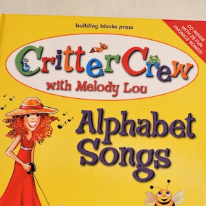 Puede incluir: Un libro amarillo con un logotipo Critter Crew rojo, blanco y azul y el título "Alphabet Songs" con Melody Lou. El libro presenta a una niña de dibujos animados con un vestido rojo paseando a un perro rojo. Se incluye un CD con 26 canciones de fonética divertidas.