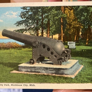 Lindo cartão postal de linho antigo de canhão no parque da cidade em Mackinaw City, Michigan