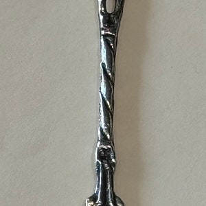 May include: Ornate silver serving fork with a decorative handle and three tines. The handle features a twisted design and a detailed top with bird-like figures. A vintage utensil for serving food.