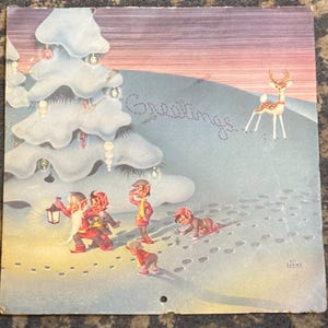May include: Vintage Christmas card illustration featuring elves in red and yellow outfits, a snow-covered tree, and a deer. The word "Greetings" is written in cursive across the snowy hill. The artwork has a retro style.