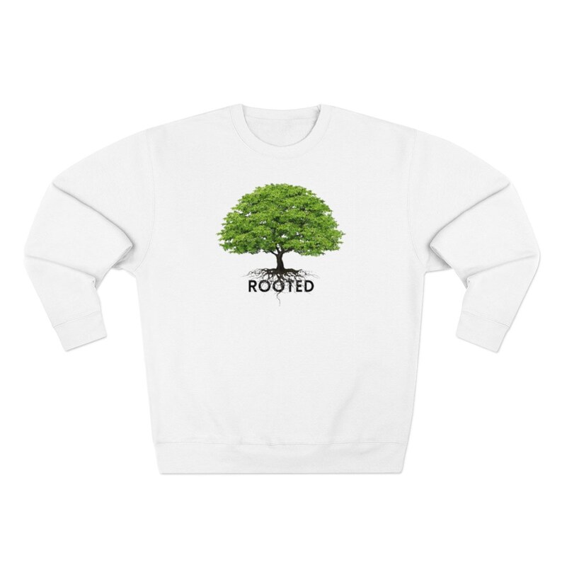 May include: White sweatshirt with a green tree graphic and the word "ROOTED" printed below it.