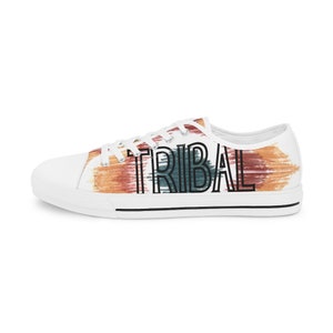 May include: White canvas low-top sneakers with a colorful abstract design and the word "TRIBAL" printed in black.