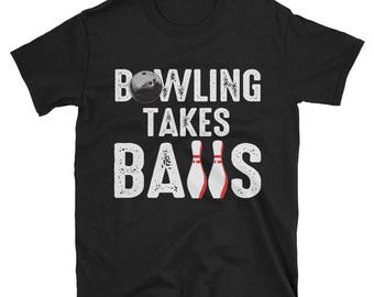 May include: Black t-shirt with white text that reads "Bowling Takes Balls" and a bowling ball and pins graphic.