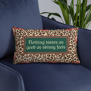 May include: A decorative throw pillow with a leopard print background and a green rectangle with the text "Nothing tastes as good as skinny feels" in a gothic font.