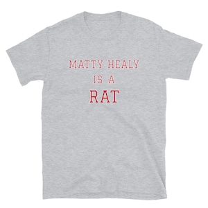 May include: A gray t-shirt with the text "Matty Healy is a Rat" printed in red.
