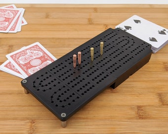 Tablero de Cribbage negro, para dos jugadores, pista continua, plegable, de metal, ideal para viajes, con compartimento para cartas. Fabricado en Montana.