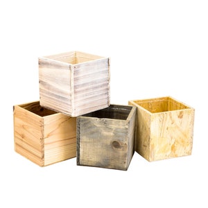 May include: Four wooden boxes of different sizes and colors. The boxes are made of different types of wood, including pine, plywood, and cedar. The boxes are all empty and have a natural finish.