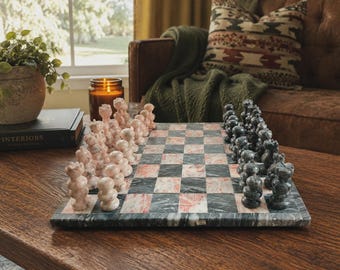 Può includere: Un set di scacchi in marmo con una scacchiera quadrata a riquadri alternati in pietra verde scuro e rosa chiaro. Il set include pezzi degli scacchi in pietra intagliata nei colori corrispondenti, disposti sui lati opposti della scacchiera.