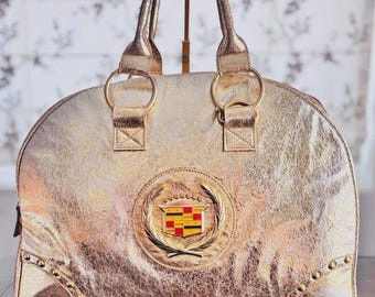 Zeldzame M Ashley Cadillac metallic gouden bowler-handtas | Grote Cadillac Collector Portemonnee | Automobielmemorabilia voor het jaar