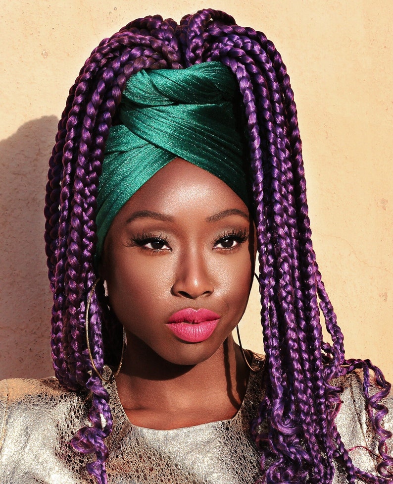 woman wearing a green velvet head wrap with purple braids