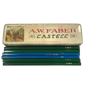 May include: Vintage A.W. Faber-Castell pencil case with pencils. The gold-coloured metal case features the brand name and a graphic of riders on horses. Several green and blue pencils are visible, some marked with "5H" and "US PAT."