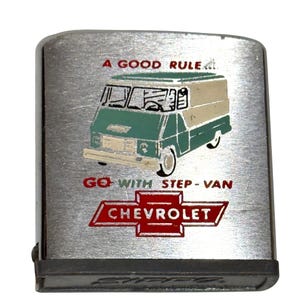 May include: A silver-toned Zippo lighter with a graphic of a green and beige step-van. The text reads "A GOOD RULE" and "GO WITH STEP-VAN" above a red Chevrolet logo.