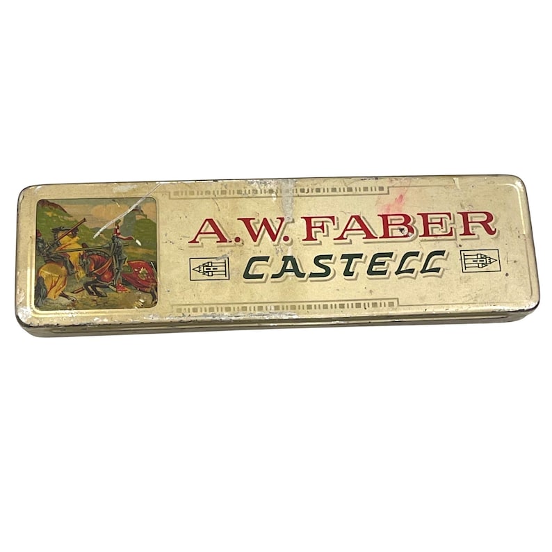 May include: Vintage A.W. Faber Castell pencil case. The rectangular tin case has a gold finish with the brand name in red and black. A small illustration of knights on horseback is on the left side of the case.