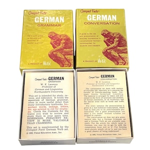 May include: Four vintage German language learning card sets. Two boxes are labeled "German Grammar" and two are "German Conversation." Each box features a yellow background with black text and a drawing of a person.