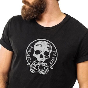 May include: A black t-shirt with a white skull and camera graphic. The graphic says "Capture Forever".