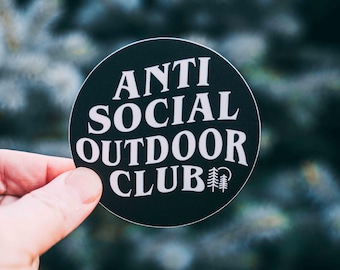 May include: A black and white sticker with the text "Anti Social Outdoor Club" and a small pine tree graphic.